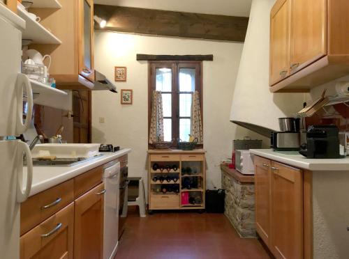 une cuisine avec des armoires en bois et une fenêtre dans l'établissement Villa charmante à Castelnou avec piscine privée, à Castelnou