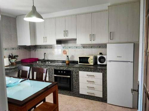 a kitchen with white cabinets and a white refrigerator at Charming House in Esteiro with Garden and Terraces in Esteiro