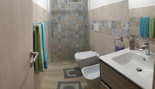 a bathroom with a sink and a toilet and a shower at 2 bedrooms apartement at Avola 150 m away from the beach with sea view enclosed garden and wifi in Avola