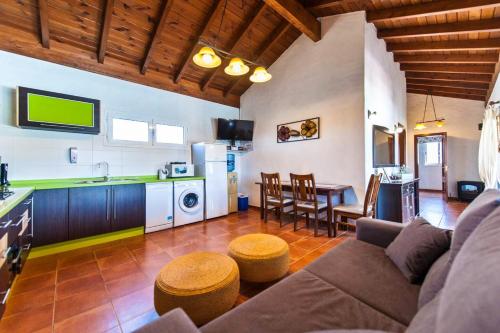 コティージョにある2 bedrooms villa with sea view private pool and jacuzzi at El Roque 1 km away from the beachのリビングルーム(ソファ、テーブル付)、キッチンが備わります。