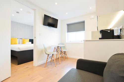 a living room with a couch and a bed at Regents Serviced Apartments by StayPrime in London