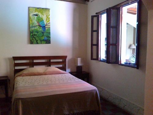 a bedroom with a bed and two windows at Casa Silas Granada Nicaragua in Granada