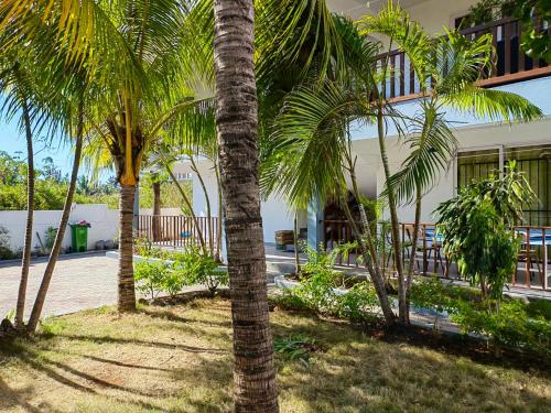 een groep palmbomen voor een gebouw bij 2 bedrooms apartement with furnished terrace and wifi at Trou aux Biches 1 km away from the beach in Trou aux Biches