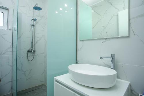 a white bathroom with a sink and a shower at VillaPhysis with Private Pool in Lardos