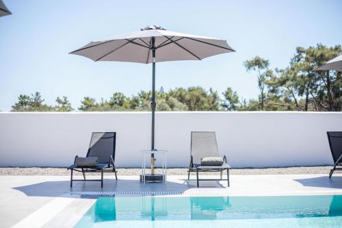 two chairs and an umbrella next to a pool at VillaPhysis with Private Pool in Lardos