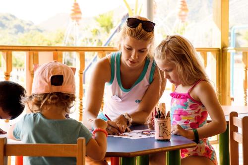 a woman and two little girls sitting at a table at Orka Lotus Beach in Marmaris