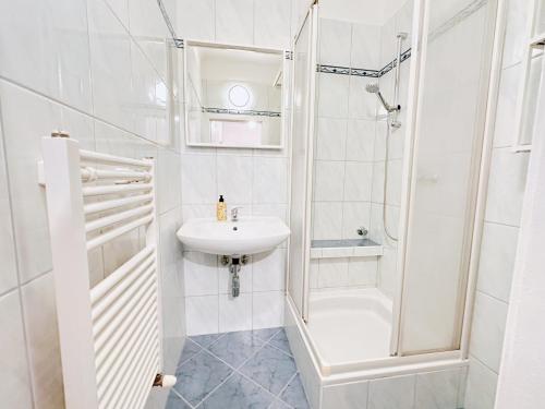 uma casa de banho branca com um lavatório e um chuveiro em Charming 3 Bedrooms Near Vienna Central Station Apartment em Viena