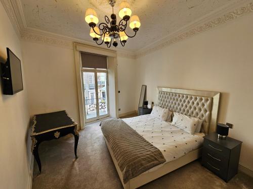 a bedroom with a large bed and a chandelier at Flat 1, Charles Street in London