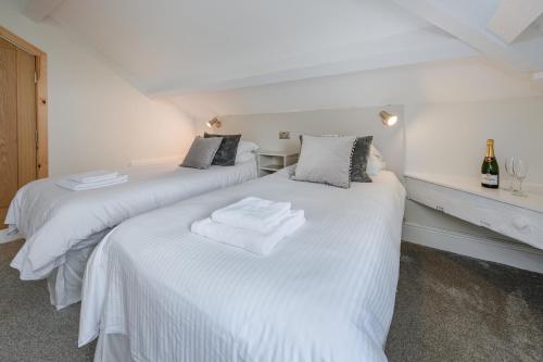 two beds in a room with white sheets at Woodlands Hall Hotel in Ederyn