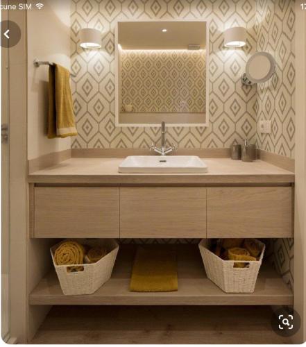 une salle de bain avec un lavabo et un miroir dans l'établissement Studio en bord de mer à Cavalaire-sur-Mer, 35 m², vue superbe., à Cavalaire-sur-Mer