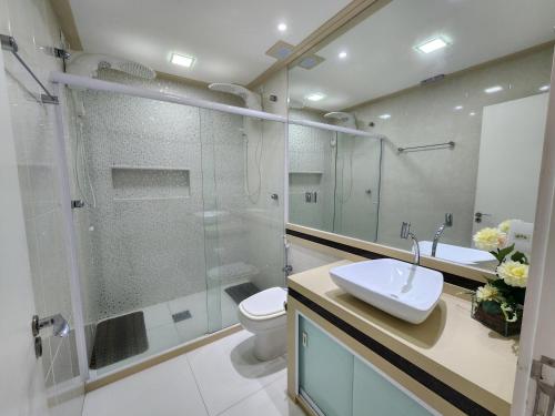 a bathroom with a shower and a toilet and a sink at AP ALECRIM Luxo Cond Aquarius I Angra dos Reis in Angra dos Reis