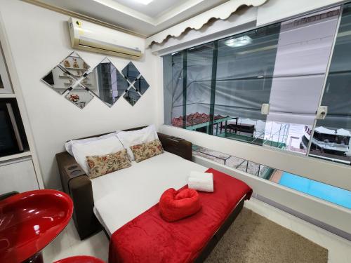 a small bedroom with a red bench and a window at AP ALECRIM Luxo Cond Aquarius I Angra dos Reis in Angra dos Reis