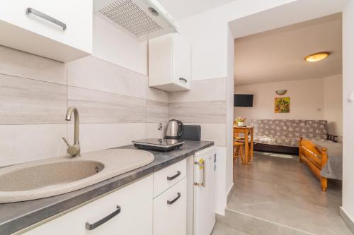 una cucina con lavello e un soggiorno di Muszelka pokoje gościnne a Sztutowo