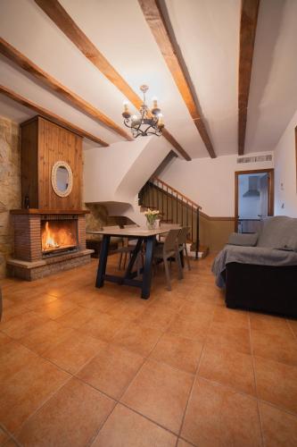 a living room with a table and a fireplace at Casas Rurales Los Olivos in Alcalá del Júcar