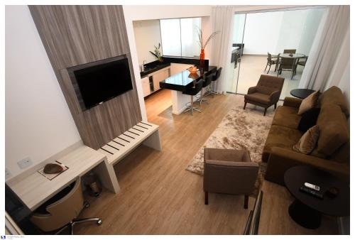 a living room with a flat screen tv and a couch at IT Itabira Hotel in Itabira