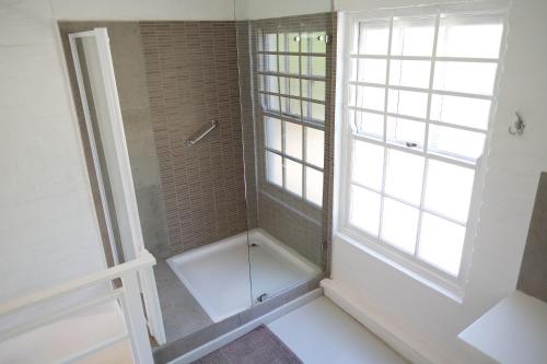 a bathroom with a shower and a window at Old Potters Inn in Greyton