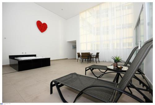 a living room with chairs and a table and a piano at IT Itabira Hotel in Itabira
