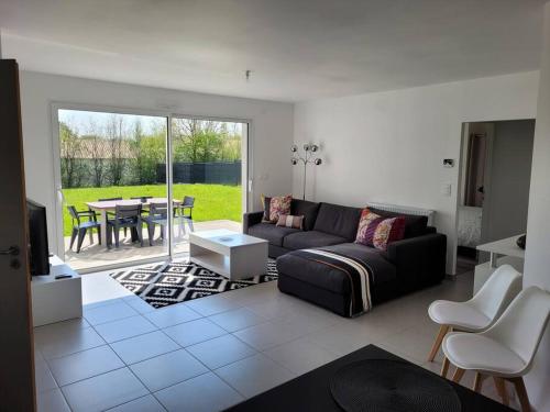 ein Wohnzimmer mit einem Sofa und einem Tisch in der Unterkunft Maison de ville neuve in Les Essarts