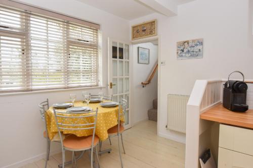 a kitchen and dining room with a table and chairs at Mulberry Cottage in Cowes