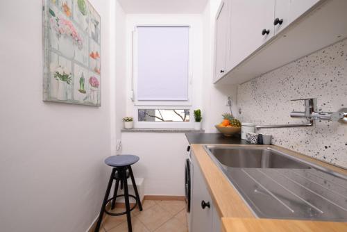 eine kleine Küche mit einem Waschbecken und einem Fenster in der Unterkunft Apartment Terrazzo in Rijeka