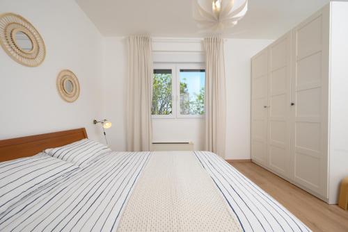 ein weißes Schlafzimmer mit einem großen Bett und einem Fenster in der Unterkunft Apartment Terrazzo in Rijeka