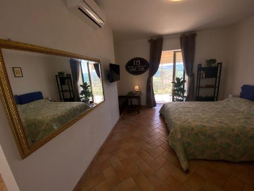 una camera con due letti e un grande specchio di Nettare e Ambrosia a Montiano