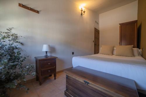 a bedroom with a bed and a table with a lamp at Casas Rurales Los Olivos in Alcalá del Júcar