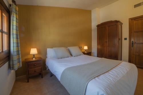 a bedroom with a large bed with two night stands and two lamps at Casas Rurales Los Olivos in Alcalá del Júcar