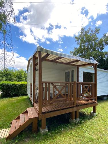une terrasse en bois avec un toit sur une petite maison dans l'établissement Mobile home PRES de Europa-Park, à Boofzheim