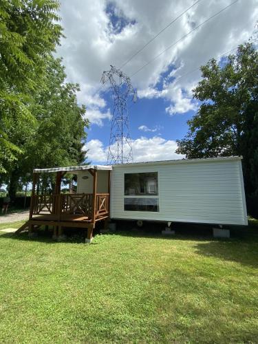 un mobile home avec une terrasse couverte sur la pelouse dans l'établissement Mobile home PRES de Europa-Park, à Boofzheim