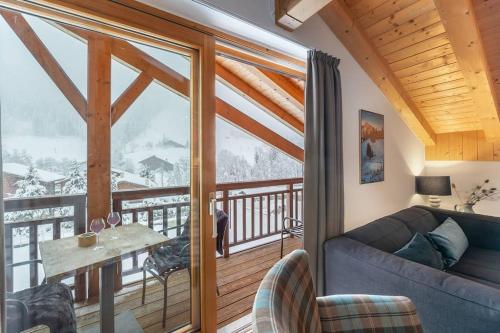 d'un salon avec un canapé et un balcon. dans l'établissement Mont Blanc - Apt 08 - BO Immobilier, à La Chapelle-dʼAbondance
