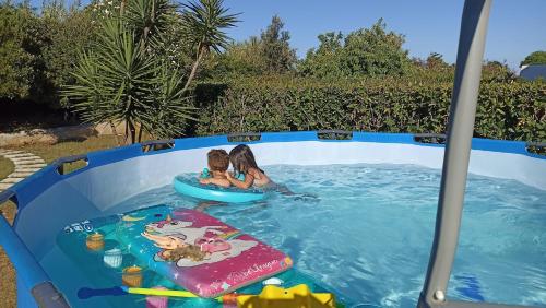 una piscina con dos chicas jugando en ella en Villetta Porto Miggiano, en Santa Cesarea Terme
