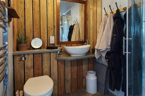 a wooden bathroom with a sink and a toilet at The Cloves Farm Shepherd’s Hut in Lydford