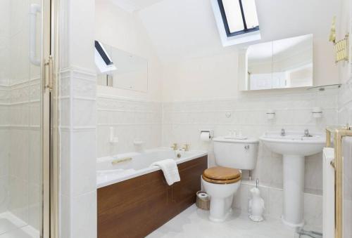 a white bathroom with a toilet and a sink at Chipping Campden - Cotswolds private house with garden in Chipping Campden