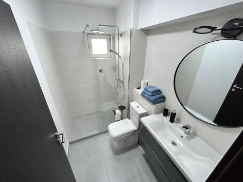 a bathroom with a toilet and a sink and a mirror at 1 Mai - Luxury Park Apartments - Self Check-in - Private parking - 1 in Craiova