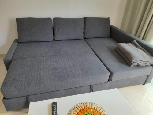 a grey couch in a living room with a remote control at Casa Lidia Costa Calma beach in Costa Calma