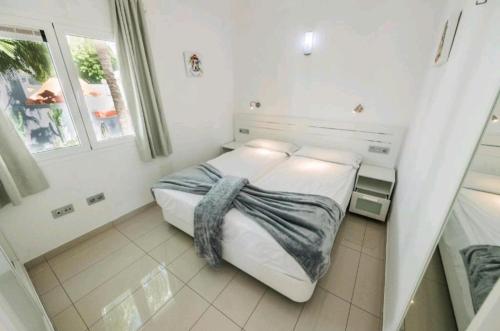 a bedroom with a bed with a blanket on it at Casa Lidia Costa Calma beach in Costa Calma