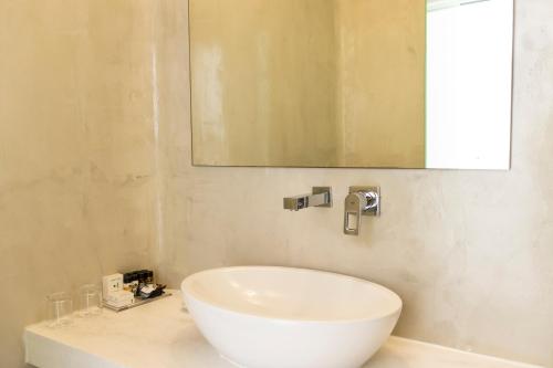 a bathroom with a white sink and a mirror at Cavo Bianco Boutique Hotel & Spa in Kamari
