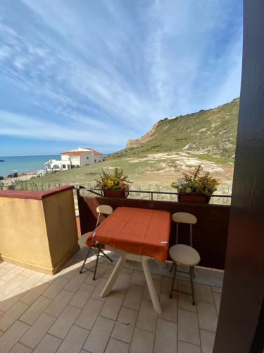 un tavolo e sedie su un balcone con vista sull'oceano di Casa Scala Dei Turchi a Realmonte