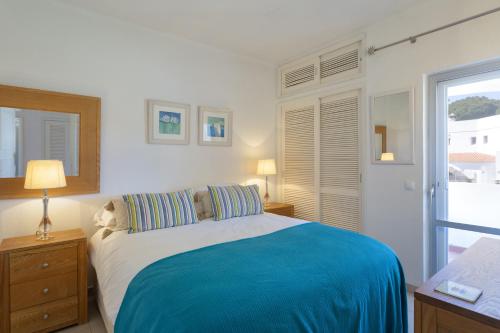 a bedroom with a bed with a blue blanket at Vila Senna in Vale do Lobo