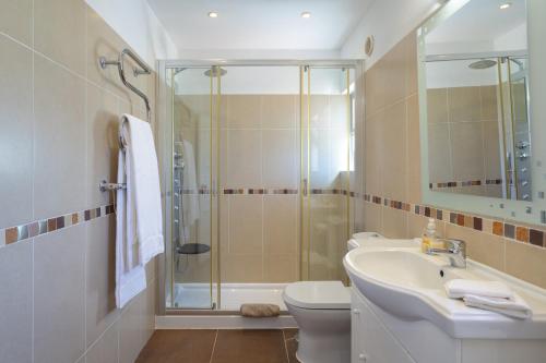 a bathroom with a shower and a sink and a toilet at Vila Senna in Vale do Lobo