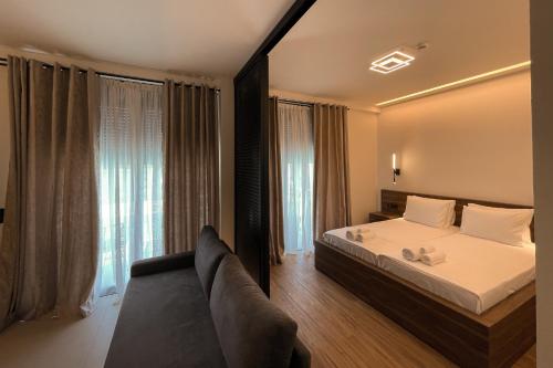 a bedroom with a bed and a couch and windows at Salt Boutique Hotel in Palouki