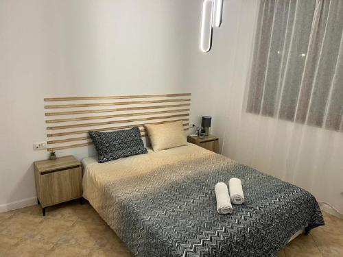 a bedroom with a bed with two white shoes on it at Eve Santa Marina Apartment II - sea, pools, relax in Sozopol