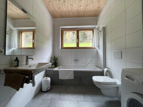 a bathroom with a tub and a sink and a toilet at Gamsfels Josephine Galeriewohnung in Langen bei Bregenz