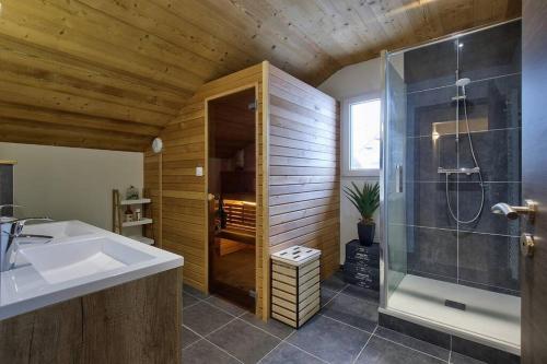 ein Bad mit einem Waschbecken und einer Dusche in der Unterkunft Chalet La Trinité-Spa,Sauna,Pétanque-Gérardmer in Gérardmer