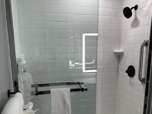 a bathroom with a glass shower door with towels at AmericInn by Wyndham Mountain Home in Mountain Home