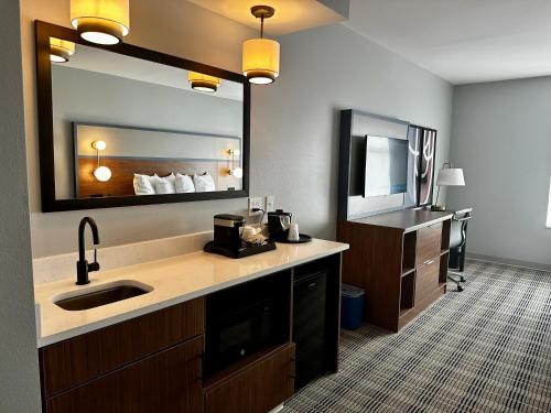 a bathroom with a sink and a large mirror at AmericInn by Wyndham Mountain Home in Mountain Home