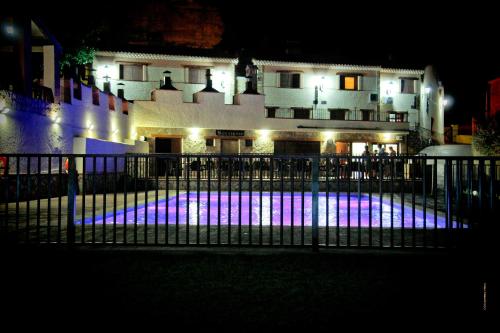 a pool in front of a building at night at Casas Rurales Los Olivos in Alcalá del Júcar