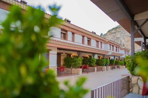 a building with chairs and plants on a street at Casas Rurales Los Olivos in Alcalá del Júcar