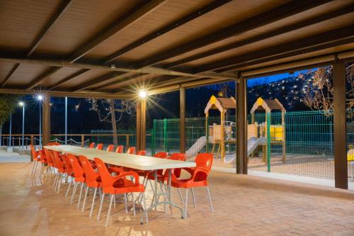 a long table and chairs with a playground in the background at Casas Rurales Los Olivos in Alcalá del Júcar
